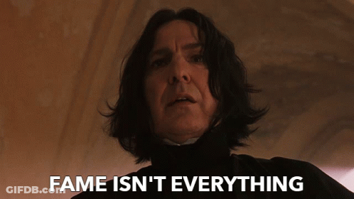 A Close Up Of A Man With The Words " Fame Isn 'T Everything " Above Him GIF