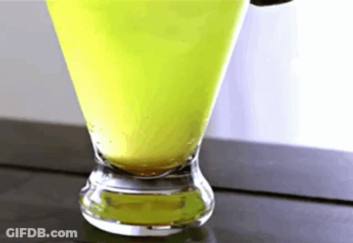 A Close Up Of A Martini Glass With A Green Liquid In It GIF