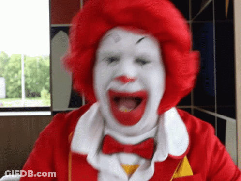 A Close Up Of A Mcdonald 'S Clown With A Red Wig And White Face . GIF