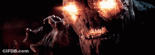 A Close Up Of A Monster With Glowing Eyes And Teeth GIF