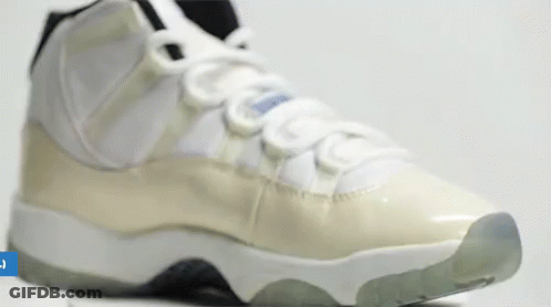 A Close Up Of A Pair Of White And Grey Sneakers On A White Surface . GIF