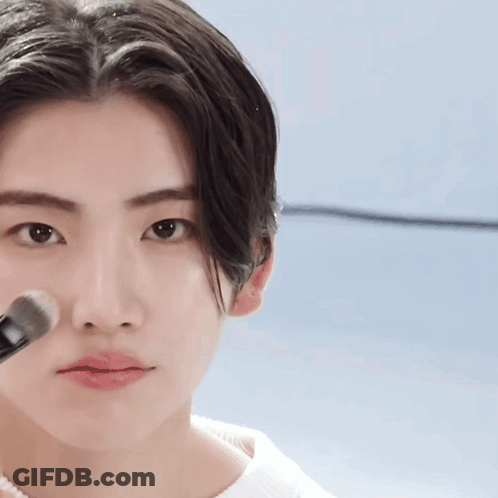 A Close Up Of A Person Applying Makeup With A Brush On Their Face GIF