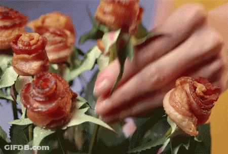 A Close Up Of A Person Arranging A Bouquet Of Roses Made Out Of Bacon GIF