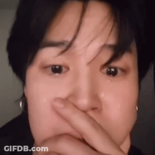 A Close Up Of A Person Covering Their Face With Their Finger . GIF