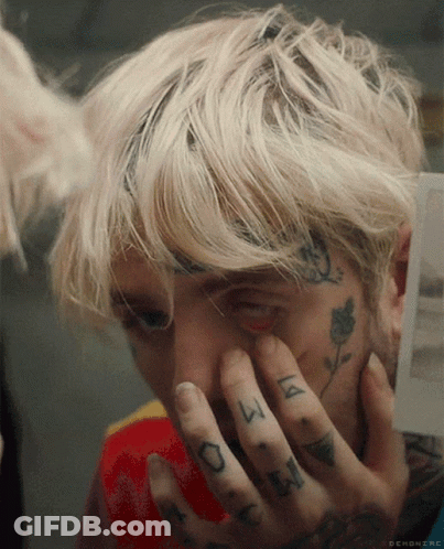 A Close Up Of A Person Covering Their Face With Their Hands With A Tattoo On Their Finger That Says ' A ' GIF