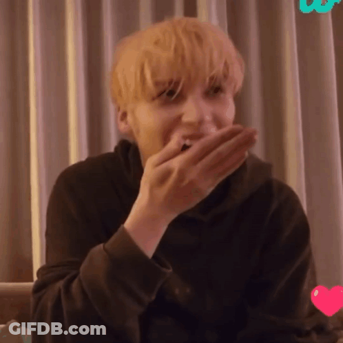 A Close Up Of A Person Covering Their Mouth With Their Hand GIF