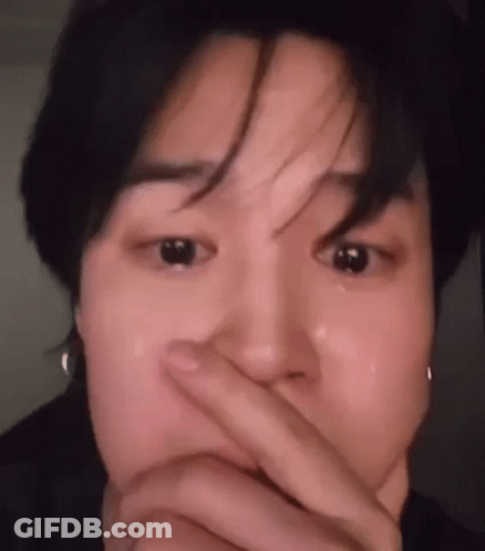 A Close Up Of A Person Covering Their Mouth With Their Hand While Crying . GIF