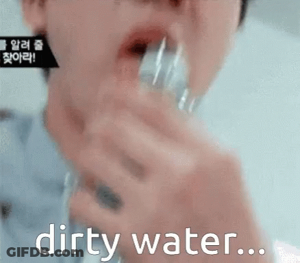 A Close Up Of A Person Drinking Dirty Water From A Glass GIF