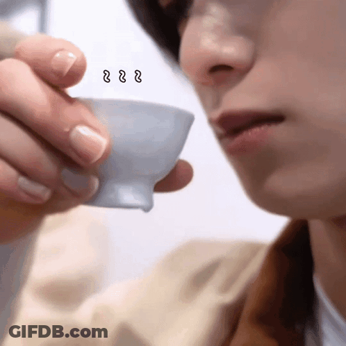 A Close Up Of A Person Drinking From A Cup With A Smiley Face On It GIF