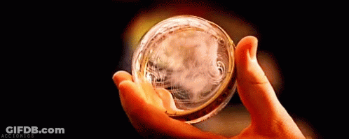 A Close Up Of A Person Holding A Glass Ball In Their Hand . GIF