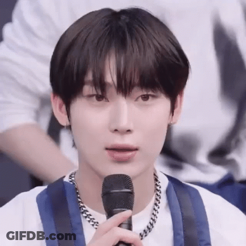 A Close Up Of A Person Holding A Microphone In Their Hand . GIF