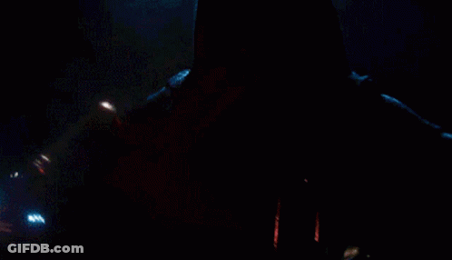 A Close Up Of A Person Holding A Red Light Saber In The Dark GIF