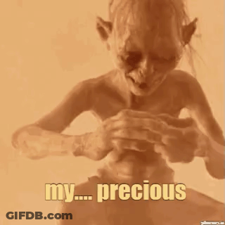A Close Up Of A Person Holding A Small Object In Their Hand With The Words `` My Precious '' Written On It . GIF