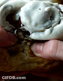 A Close Up Of A Person Holding A Statue With White Frosting On It GIF