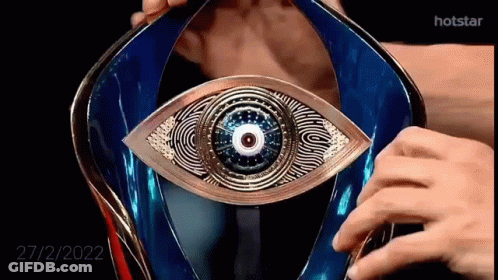 A Close Up Of A Person Holding A Trophy With An Eye In It . GIF