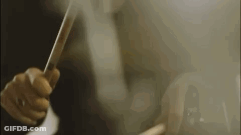 A Close Up Of A Person Holding A Trumpet In A Dark Room . GIF
