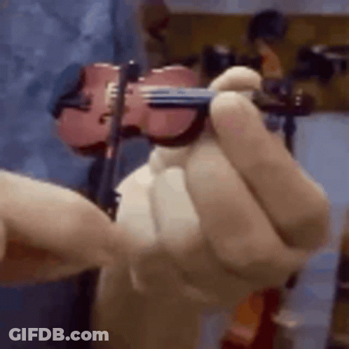 A Close Up Of A Person Holding A Violin In Their Hand . GIF