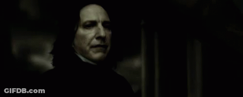 A Close Up Of A Person Holding A Wand In A Dark Room In A Movie . GIF