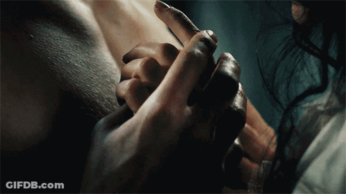 A Close Up Of A Person Holding Another Person 'S Hand In A Dark Room GIF