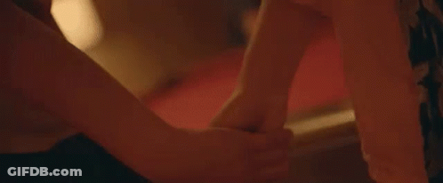A Close Up Of A Person Holding Another Person 'S Hand While Laying On A Bed . GIF