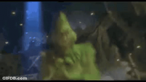 A Close Up Of A Person In A Green Costume Laying On The Ground . GIF