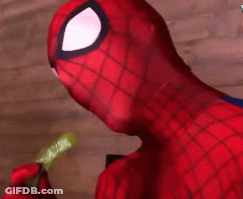 A Close Up Of A Person In A Spiderman Costume Eating A Pickle . GIF