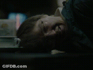 A Close Up Of A Person Laying Down With Their Head On A Table GIF