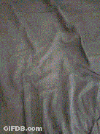 A Close Up Of A Person Laying On A Bed Covered In Sheets GIF