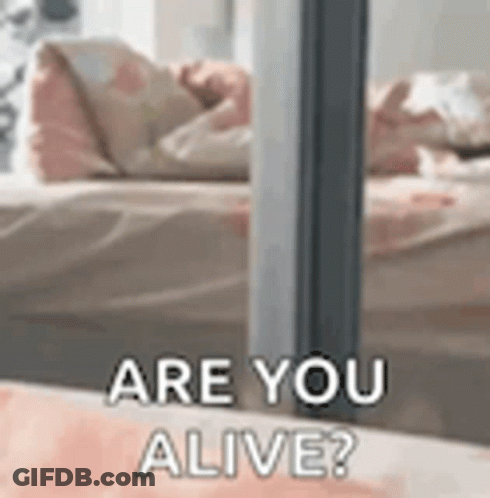 A Close Up Of A Person Laying On A Bed With The Words `` Are You Alive '' Written On It . GIF