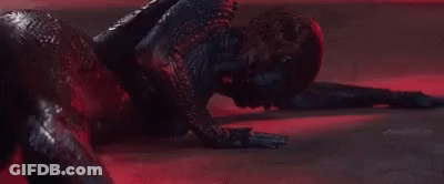A Close Up Of A Person Laying On The Floor In A Dark Room With A Red Light Behind Them . GIF