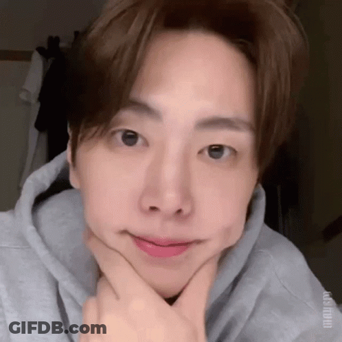 A Close Up Of A Person Making A Face With Their Hands On Their Chin . GIF