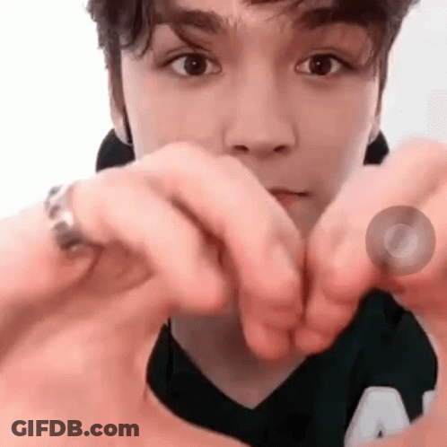 A Close Up Of A Person Making A Heart With Their Hands . GIF