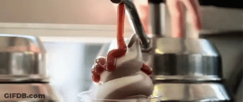 A Close Up Of A Person Pouring Whipped Cream Into A Cup . GIF