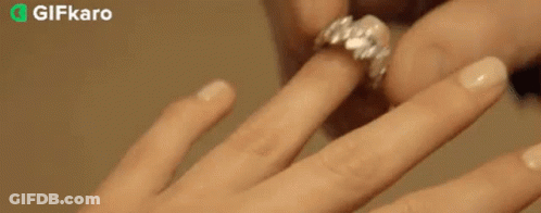 A Close Up Of A Person Putting A Ring On Another Person 'S Finger . GIF