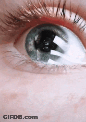 A Close Up Of A Person 'S Blue Eye With Long Eyelashes GIF