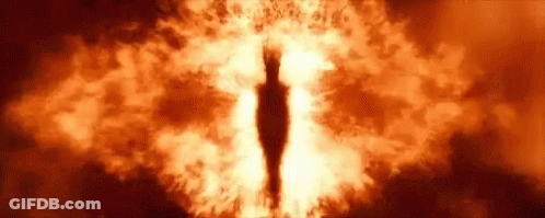 A Close Up Of A Person 'S Eye Surrounded By Flames In A Dark Room . GIF