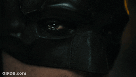 A Close Up Of A Person 'S Eye Wearing A Batman Mask GIF