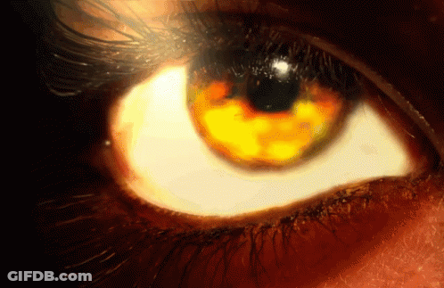 A Close Up Of A Person 'S Eye With A Yellow Glow In It GIF