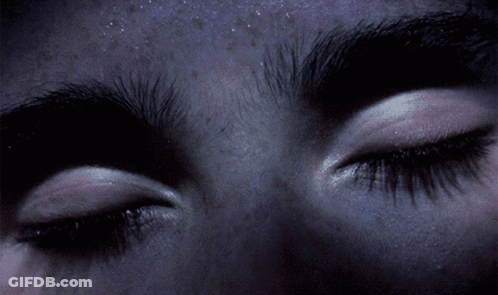 A Close Up Of A Person 'S Eyes With A Purple Background GIF