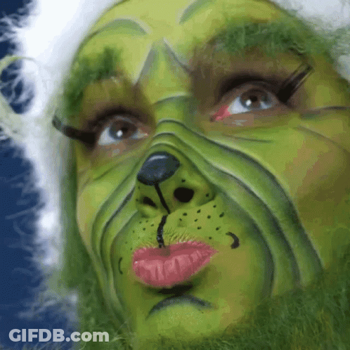 A Close Up Of A Person 'S Face Painted To Look Like A Grinch GIF