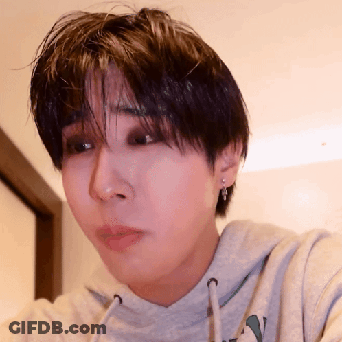 A Close Up Of A Person 'S Face Wearing A Grey Hoodie GIF