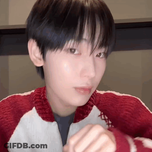 A Close Up Of A Person 'S Face Wearing A Red And White Sweater . GIF