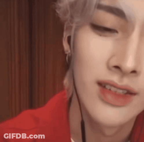 A Close Up Of A Person 'S Face Wearing Headphones And A Red Shirt . GIF