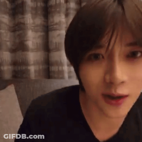 A Close Up Of A Person 'S Face With A Black Shirt On And A Curtain In The Background . GIF