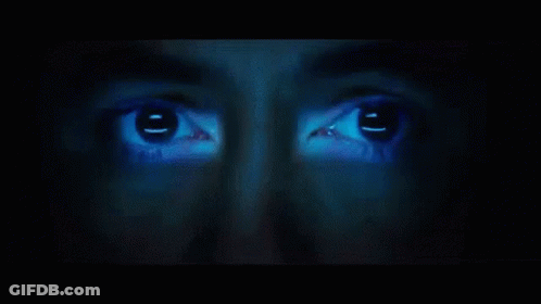 A Close Up Of A Person 'S Face With A Blue Light Shining On It GIF