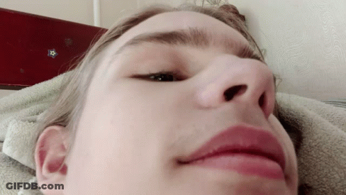 A Close Up Of A Person 'S Face With A Blue Star On The Wall Behind Them GIF