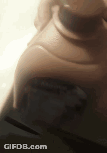 A Close Up Of A Person 'S Face With A Blurred Background And A Button That Says ' A ' On It GIF