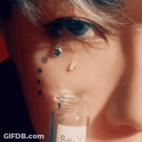 A Close Up Of A Person 'S Face With A Bottle Of Boy 'S On It GIF