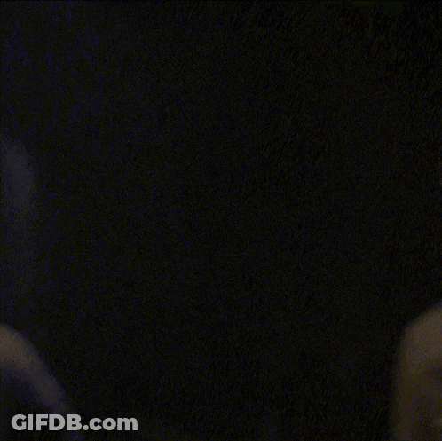 A Close Up Of A Person 'S Face With A Dark Background GIF
