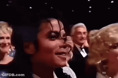 A Close Up Of A Person 'S Face With A Group Of People Behind Them . GIF